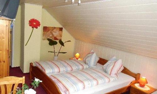 a bedroom with a white bed with pillows on it at Pension Renate Braun in Gamstädt