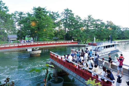 a group of people on a bridge over a river at Morizuya in Toyooka