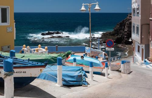 a group of boats parked next to the ocean at Fronton Whale Apartamentos in Gáldar