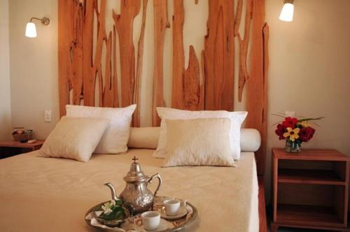 una camera con letto e testata in legno di Pousada Dona Flor a Canoa Quebrada