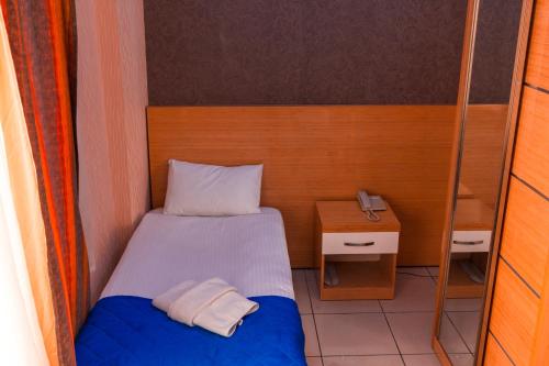 a small bedroom with a bed and a telephone at Pera City Hotel in Ankara