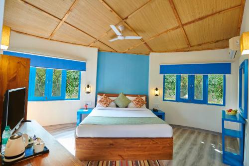 a bedroom with a bed and blue walls at Aacorn Hideaway Resort & Spa in Rāmnagar