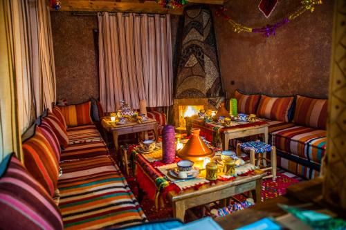 uma sala de estar com dois sofás e duas mesas em Toubkal Ecolodge em Imlil