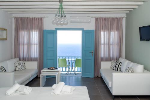 a living room with blue and white furniture and a table at Aeri in Chora Folegandros