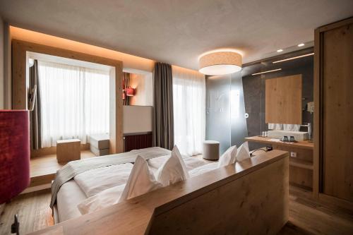 - une chambre avec un grand lit blanc dans l'établissement Das Panorama Designhotel, à Caldaro