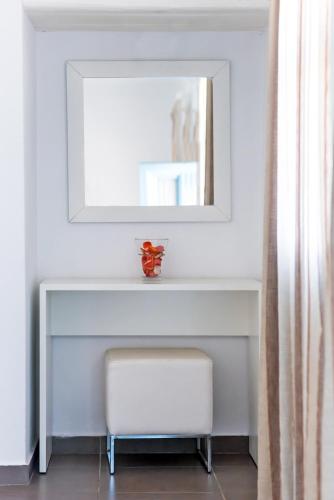a white table with a mirror and a stool at Aeri in Chora Folegandros
