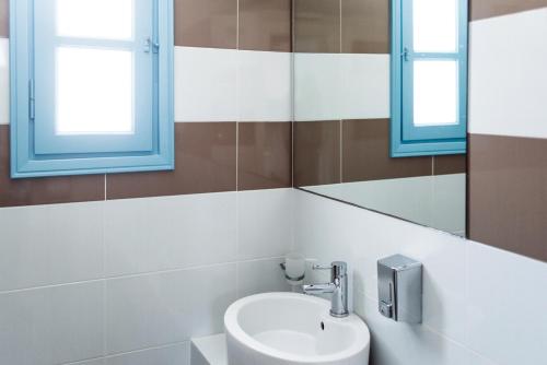 a bathroom with a sink and two windows at Aeri in Chora Folegandros