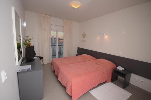 a bedroom with a bed and a flat screen tv at Boutique & Villas Boliqueime in Boliqueime