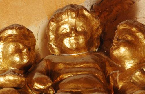 a bronze statue of two people on a wall at El Beaterio Casa Museo in Santo Domingo