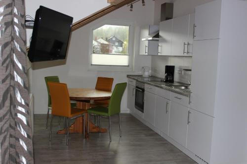 eine Küche mit einem Tisch und Stühlen sowie einem TV in der Unterkunft Ferienwohnung in Marburg/Wehrda in Marburg an der Lahn