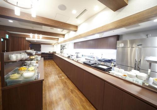 a large kitchen with a long counter with food on it at Dormy Inn Hiroshima in Hiroshima