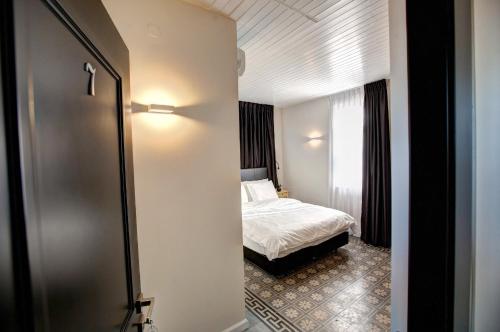 a hotel room with a bed and a door to a bedroom at City Port Hotel in Haifa