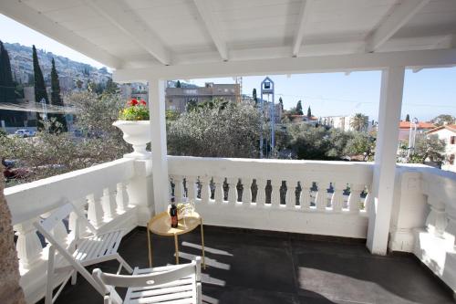 a white porch with a table and chairs on it at City Port Hotel in Haifa