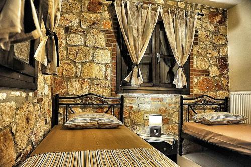 プサコウディアにあるVilla Eleanaの石壁のベッドルーム1室(ベッド2台付)