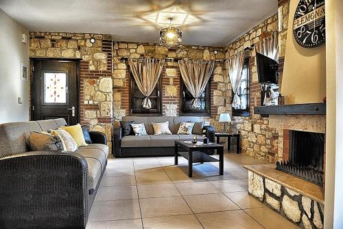 ein Wohnzimmer mit einem Sofa und einem Kamin in der Unterkunft Villa Eleana in Psakoudia
