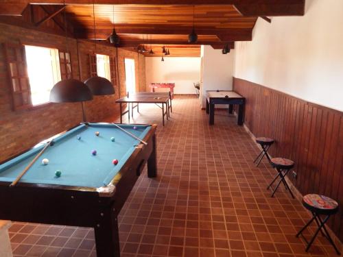 a pool table in a room with two tables and chairs at Pousada Chalés da Felicidade in Itu