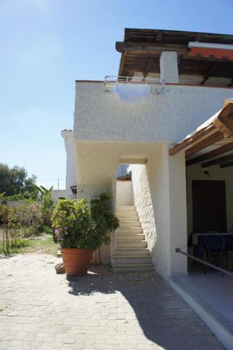 a white house with stairs and a potted plant at Locanda FarOrientale in Santa Lucia
