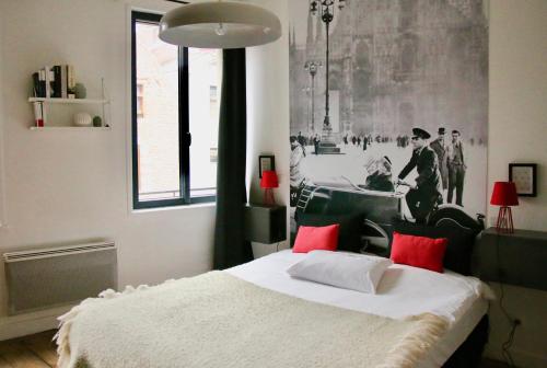 a bedroom with a bed and a painting on the wall at Princesse Apart'hôtel in Lille