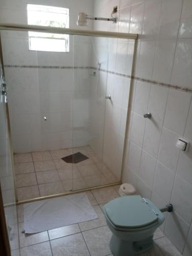 a bathroom with a shower with a toilet and a window at La Riviera Pousada Pantanal in Itanhaém