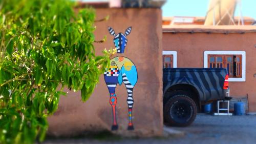 a painting of a giraffe on the side of a wall at Camping Auberge Zebra in Ouzoud