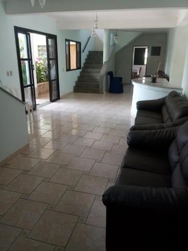 a living room with a couch and a tile floor at La Riviera Pousada Pantanal in Itanhaém
