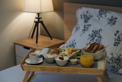 a tray of food on a table in a bedroom at Apartament White in Śrem
