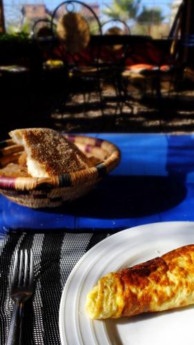 a slice of pizza on a plate on a table at Camping Auberge Zebra in Ouzoud