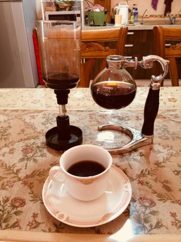 a cup of coffee on a table with a blender at Hope & Sea Homestay in Hualien City