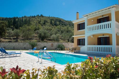 een villa met een zwembad en een huis bij Florena Villas in Spanokhórion