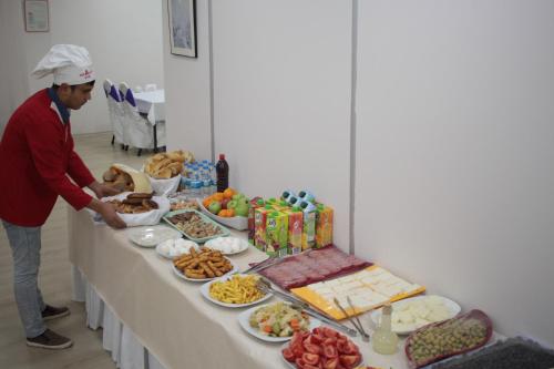 a man standing in front of a table of food at Pera City Hotel in Ankara