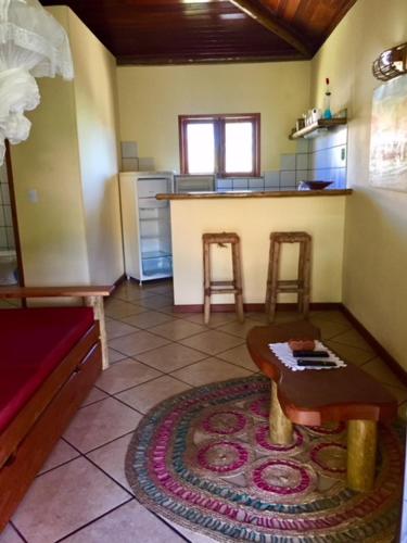 a living room with a table and a kitchen at Bahiadomizil in Canavieiras