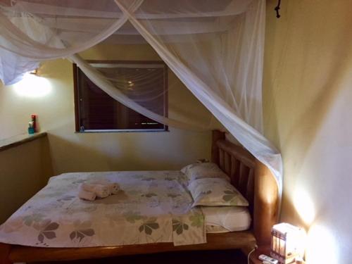 una camera con letto a baldacchino e finestra di Bahiadomizil a Canavieiras