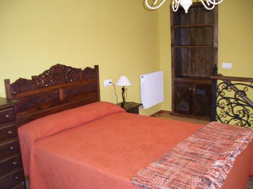 a bedroom with a large bed with a orange bedspread at Apartamento Sopiedra in Nueva de Llanes