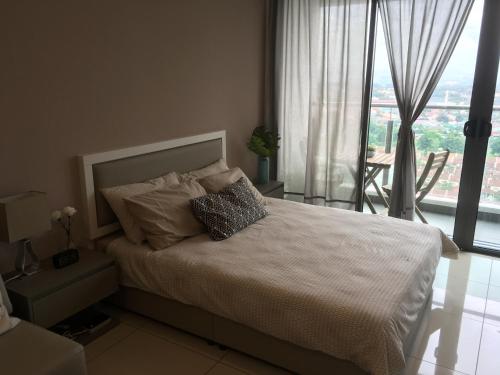 a bedroom with a bed and a large window at Damaye Evo Soho Suites in Central Bangi in Kampong Sungai Ramal Dalam