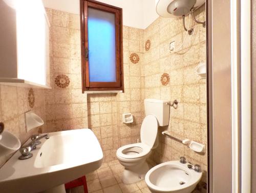 a bathroom with a toilet and a sink at Villetta Marfisa in Lido di Spina