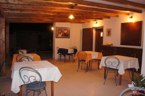 a room with tables and chairs and a kitchen at Locanda FarOrientale in Santa Lucia