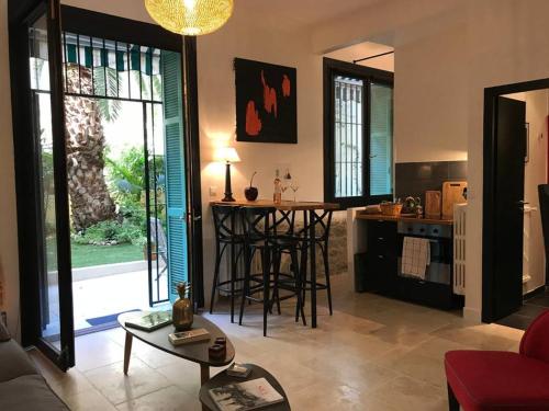 un salon avec une table et une cuisine dans l'établissement Homelivia, Luxueux Appartement avec Jardin privé, à Nice