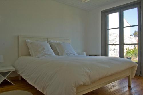 a white bed with white sheets and pillows in a bedroom at 269 Bel Ebat in Le Bois-Plage-en-Ré