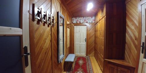 un corridoio con pannelli in legno e una porta con panca di Apartments in Villa Barbara a Świeradów-Zdrój