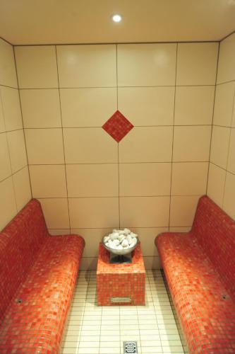 a room with two red couches and a bowl of balls at Waldhotel Felschbachhof in Ulmet
