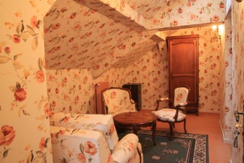 a room with floral wallpaper and a table and chairs at Château Des Bondons EI in La Ferté-sous-Jouarre