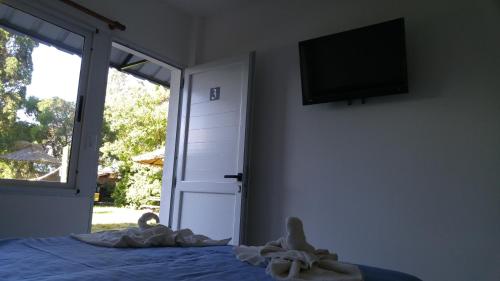 ein Schlafzimmer mit einem Bett und einem Fernseher an der Wand in der Unterkunft Hotel El Faro in Villa Gesell
