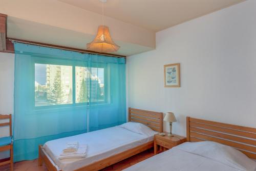 アルマカオ・デ・ペラにあるFLH Armação de Pêra Beach Apartmentのベッドルーム1室(ベッド2台、窓付)
