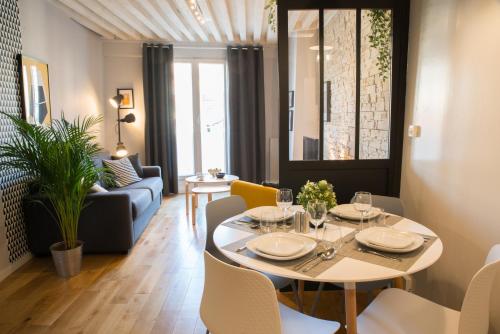 un salon avec une table et un canapé dans l'établissement Le Sathonay - Loft Terrasse - Lyon Centre - Majord'Home, à Lyon
