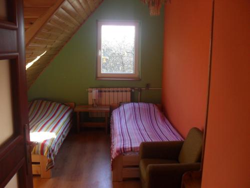 a small room with two beds and a window at Pohulanka - Białowieża in Kolonia Pohulanka