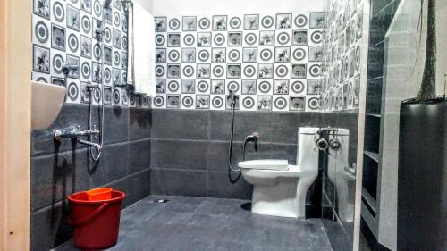 a black and white bathroom with a toilet and a bucket at Marari Nadiya in Mararikulam