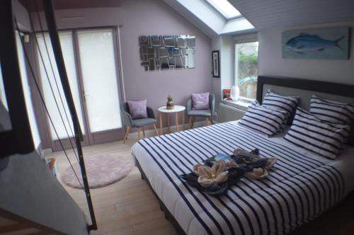 - une chambre avec un grand lit aux rayures bleues et blanches dans l'établissement Mon petit coin de Bretagne, à Riantec