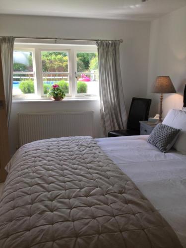 um quarto com uma cama grande e uma janela em Little Owl Barn em Marlborough