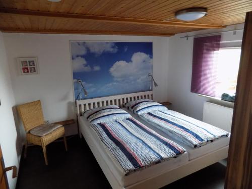a bedroom with a bed with a painting on the wall at Leuchtturm in Friederikensiel