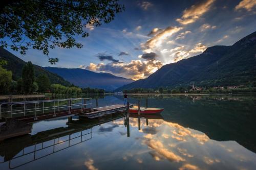 a boat is docked at a dock on a lake at CASA VACANZA Residence Lago di Endine in Monasterolo del Castello